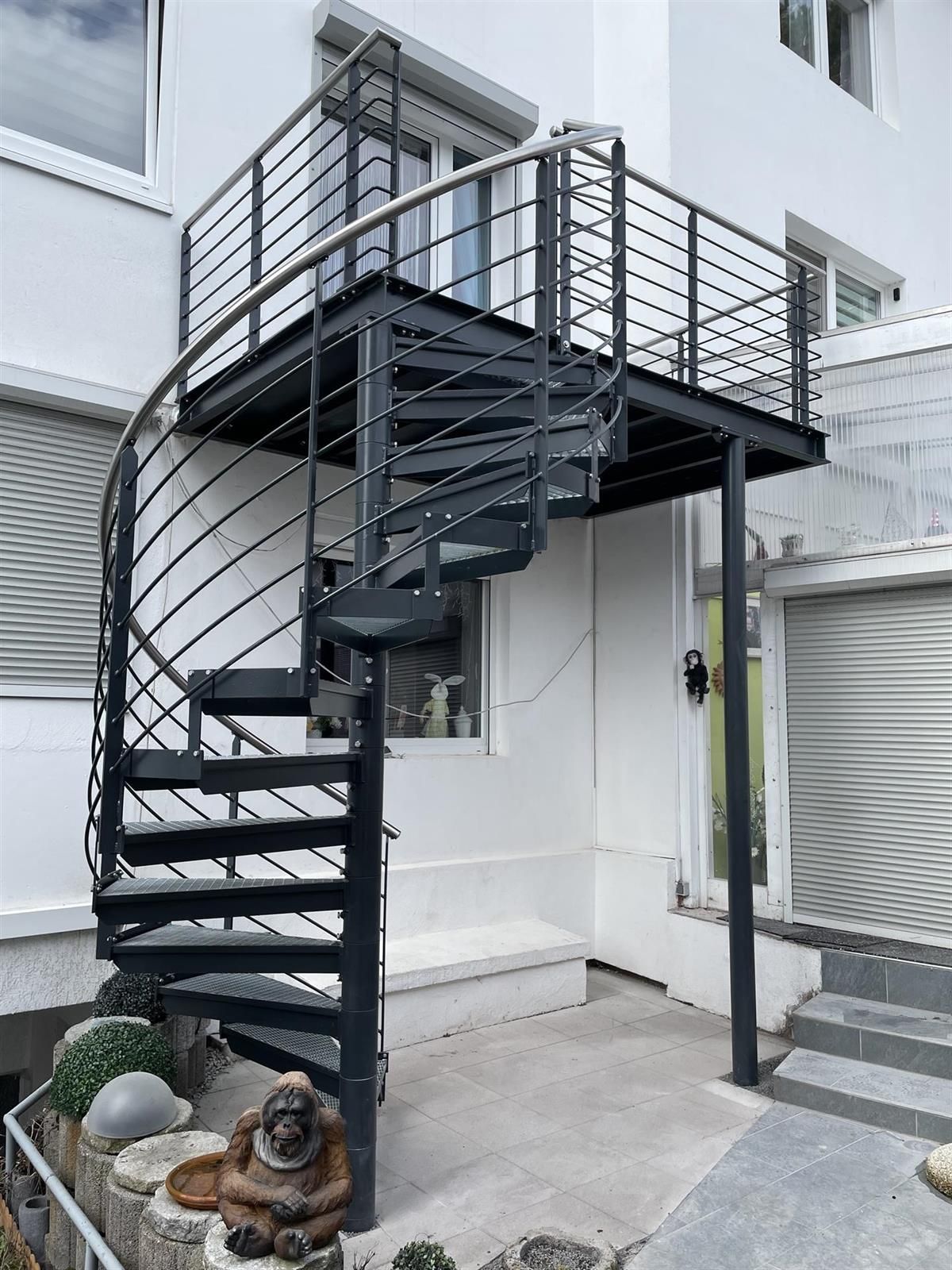 Eine Wendeltreppe, die zu einem Balkon an der Seite eines Gebäudes führt