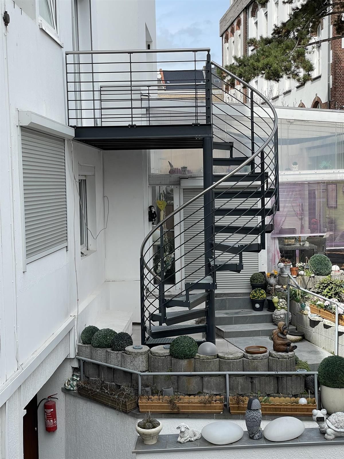 Eine Wendeltreppe, die zu einem Balkon an der Seite eines Gebäudes führt