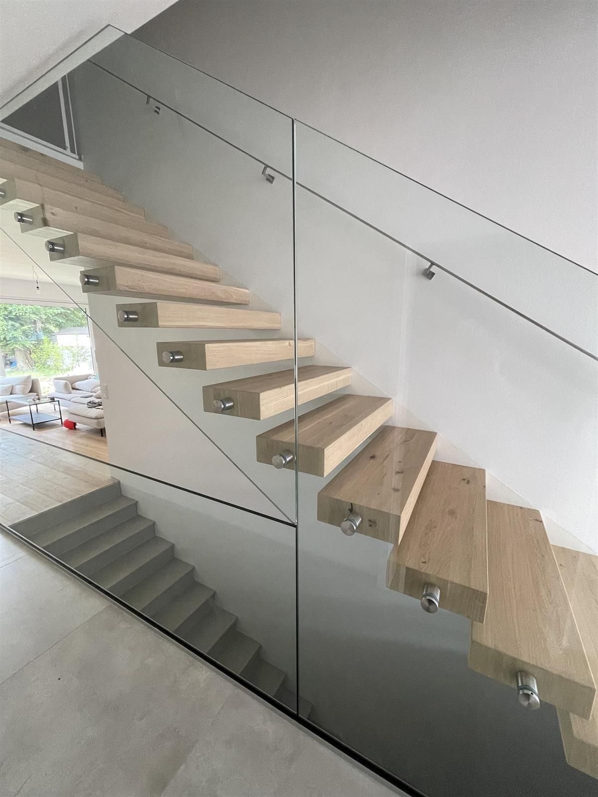 Eine Treppe mit Holzstufen und einem Glasgeländer