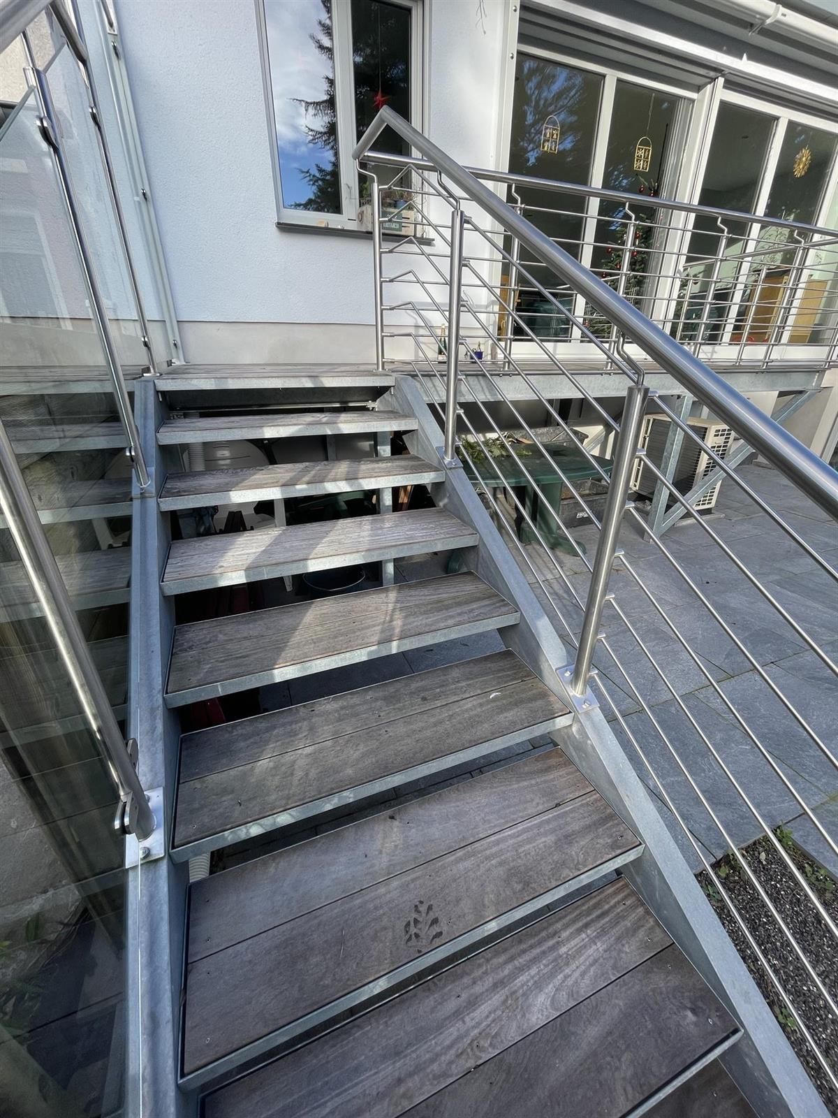 Eine Reihe von Holztreppen mit einem Geländer aus Edelstahl