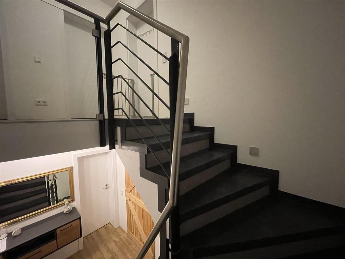 Eine Treppe mit einem Metallgeländer und einem Spiegel