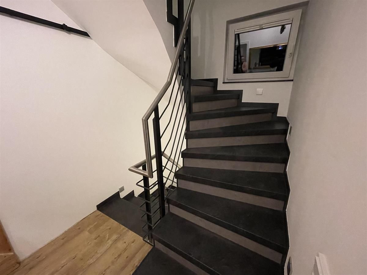 Eine Wendeltreppe mit einem Metallgeländer und einem Fenster