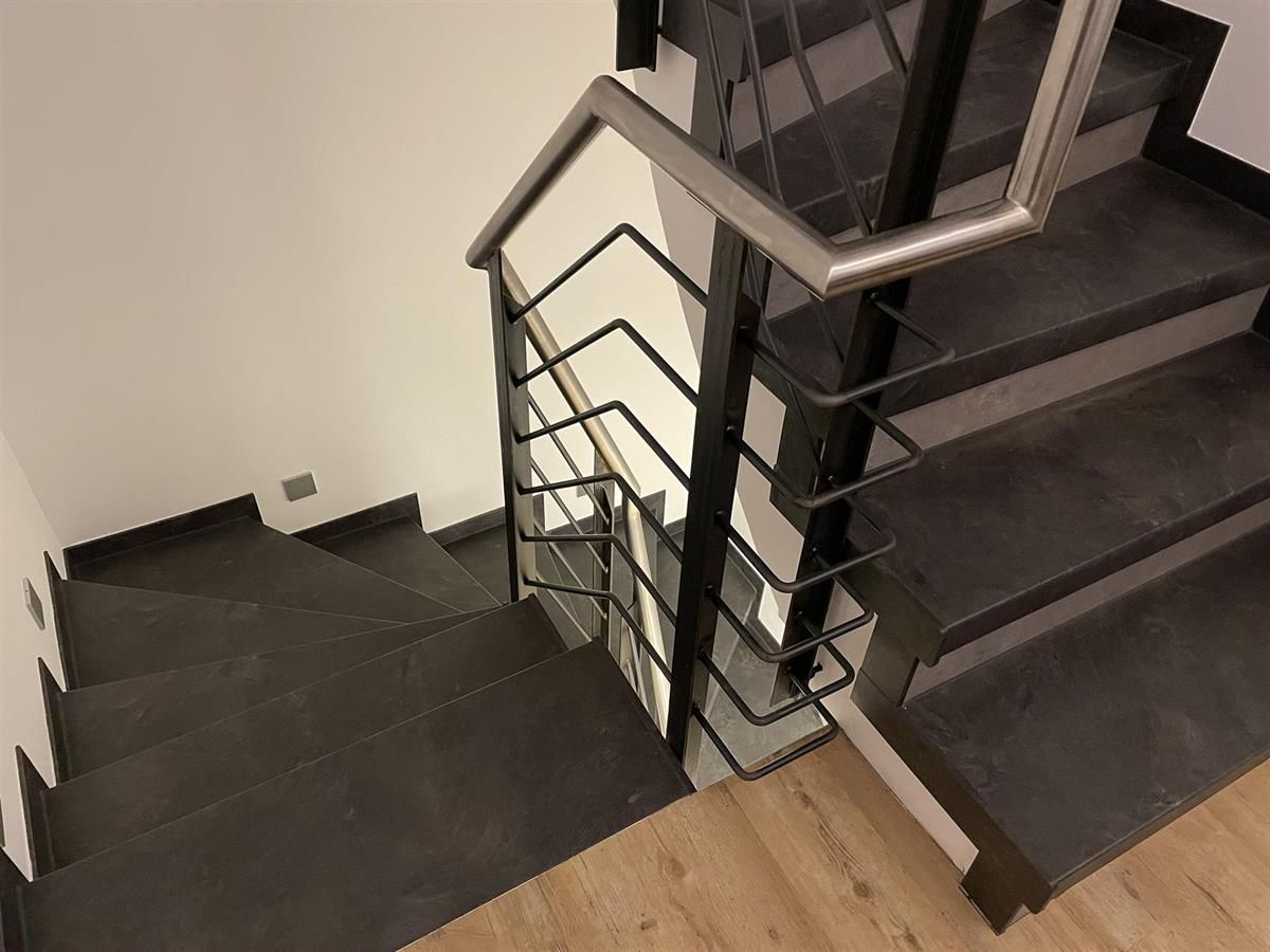 Eine Treppe mit Metallgeländer und Holzboden