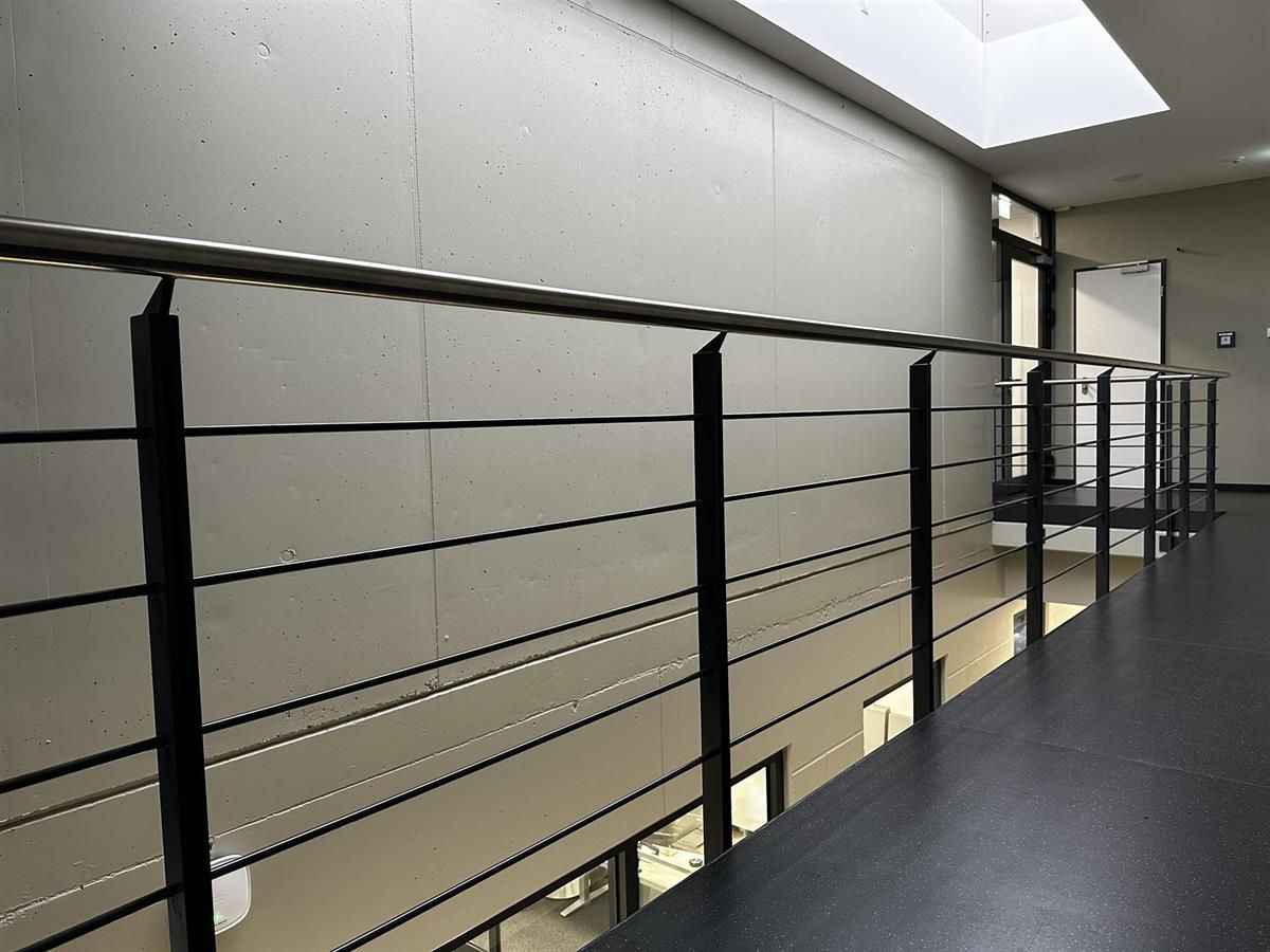 Ein Flur mit schwarzem Geländer und Oberlicht