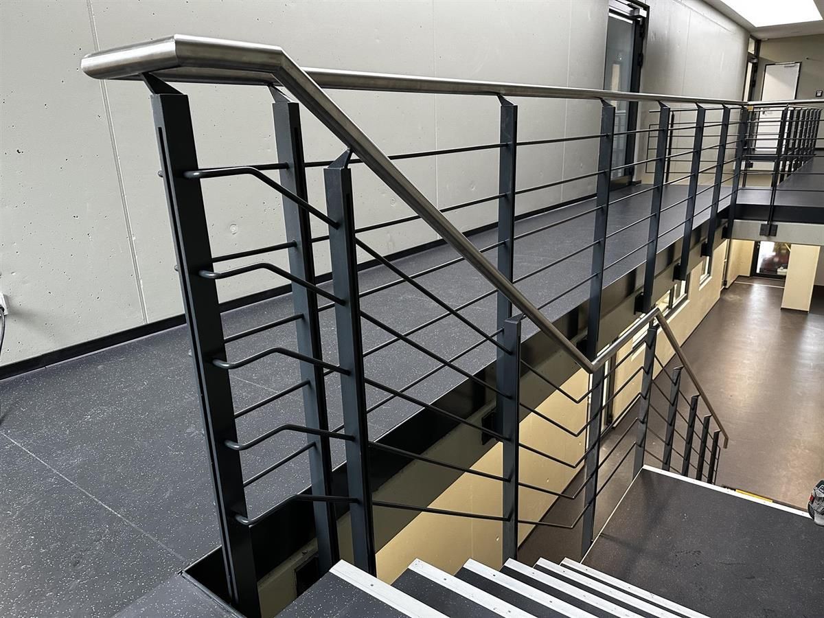 Eine Treppe mit einem Edelstahlgeländer in einem Gebäude
