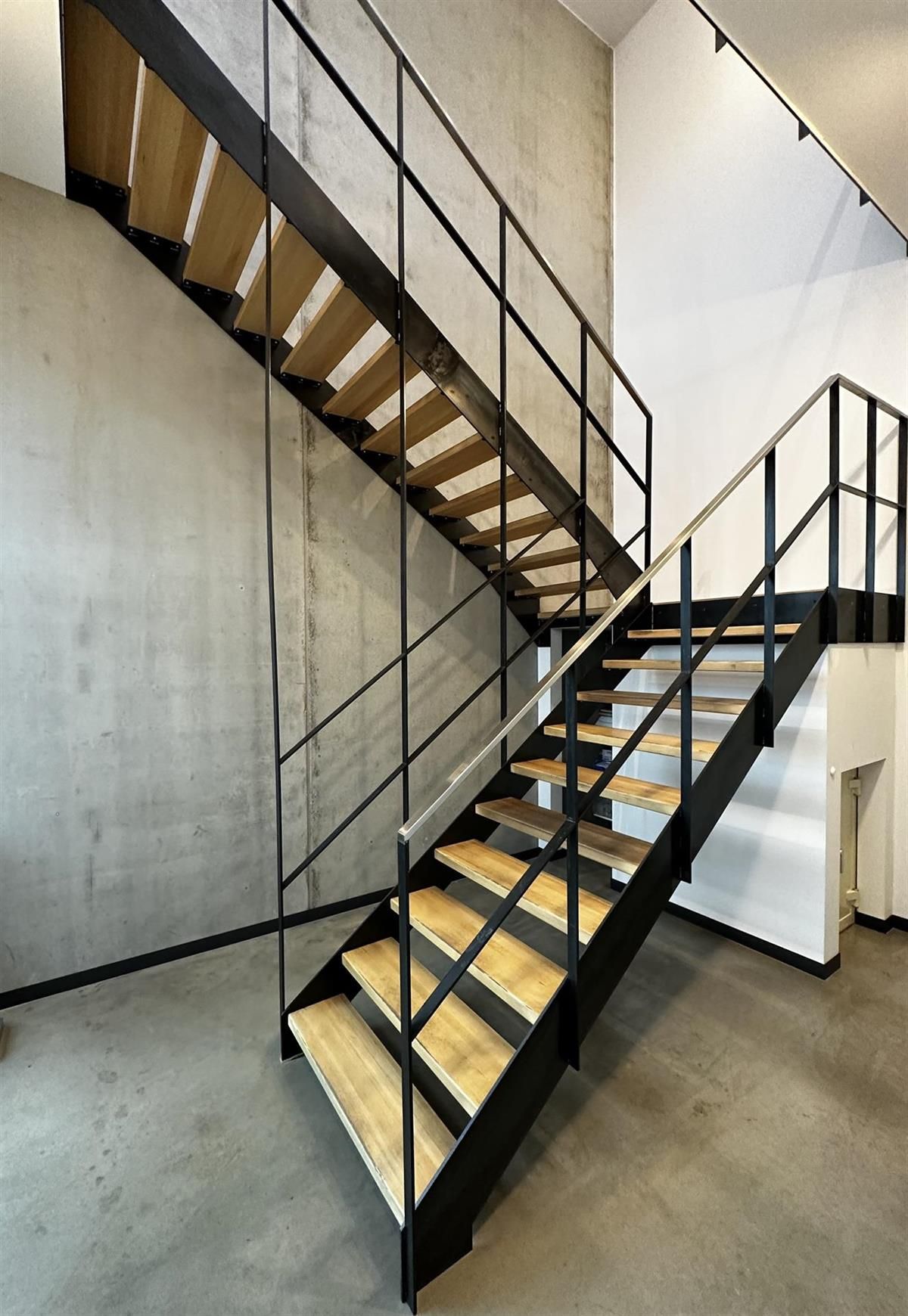 Eine Treppe mit Holzstufen und einem Metallgeländer