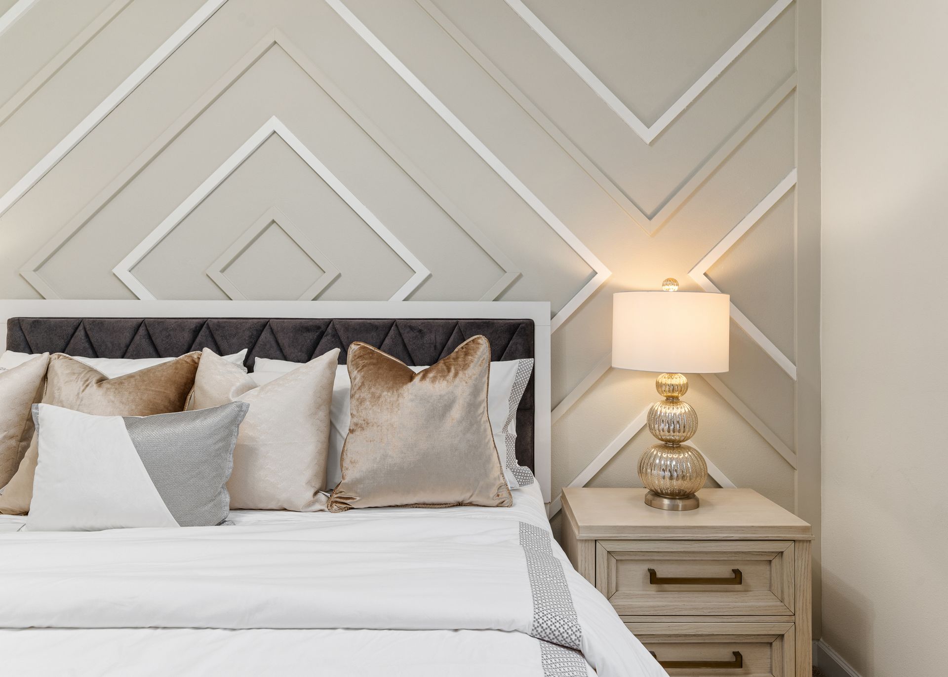 A bedroom with a bed , nightstand and lamp.