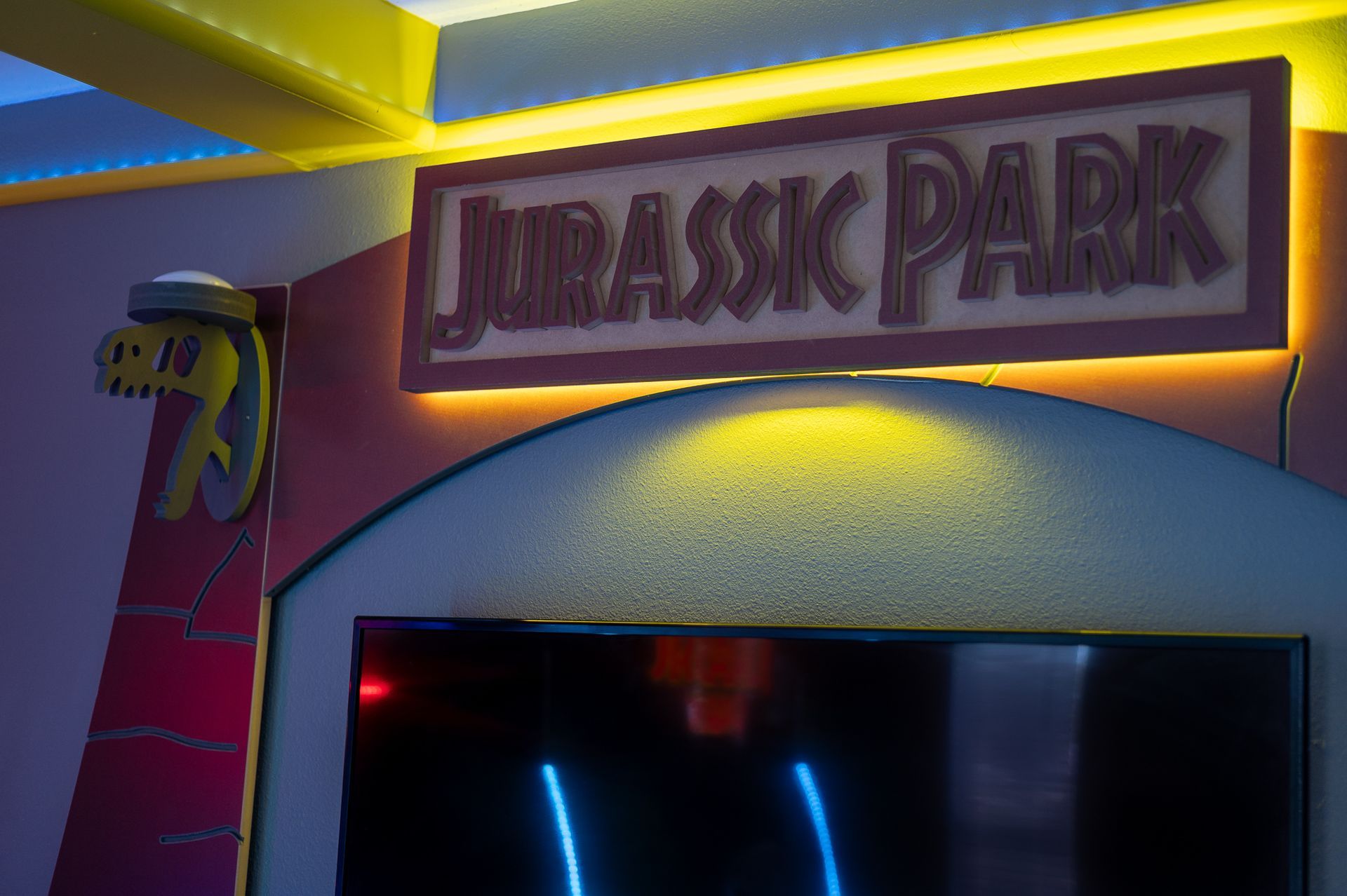 Jurassic Park sign above a screen with blue neon.