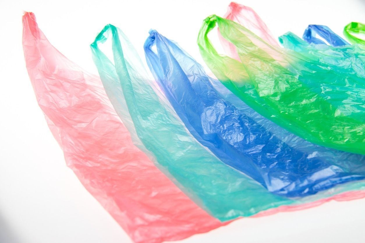 Una fila de bolsas de plástico de colores sobre un fondo blanco.