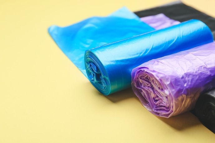 Tres rollos de bolsas de plástico se apilan uno encima del otro sobre una mesa.