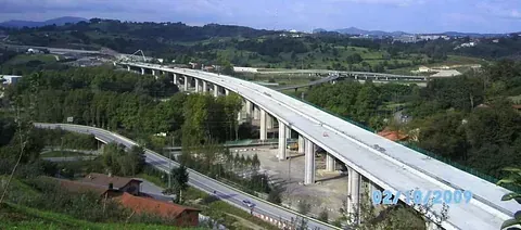 Autopista elevada con varios vehículos circulando sobre un valle verde, de fecha 16/02/2001.
