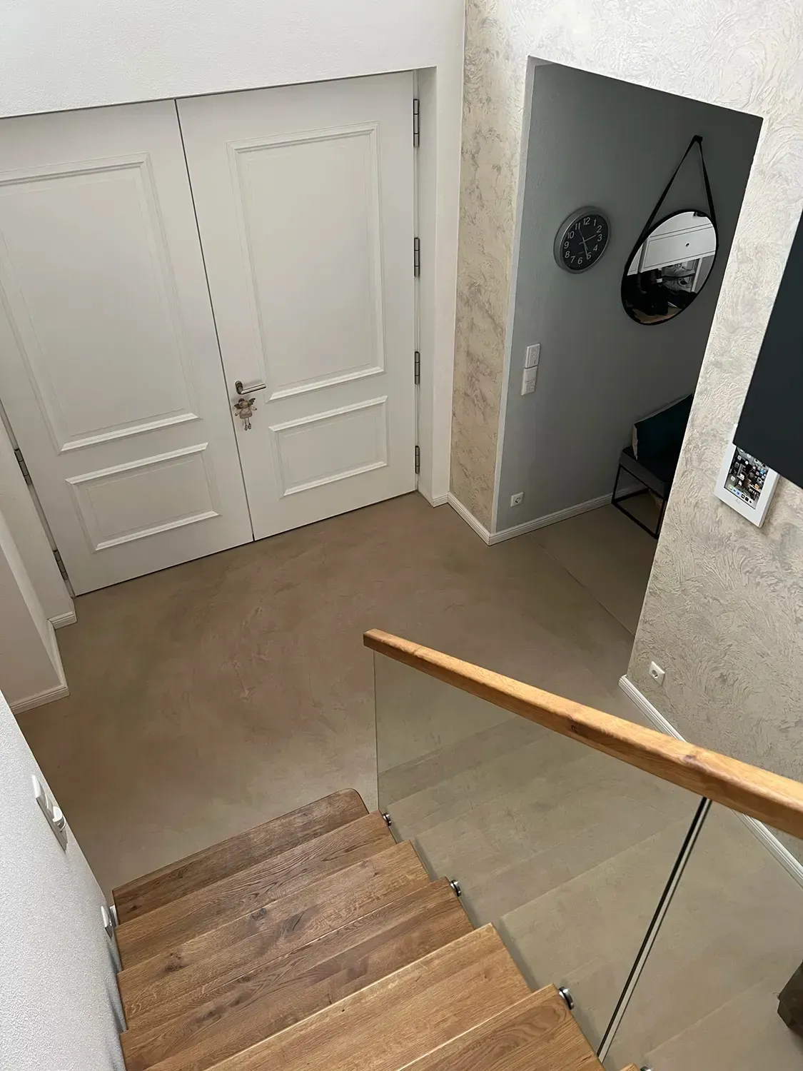 Eine Luftaufnahme eines Flurs mit Treppe und Glasgeländer.