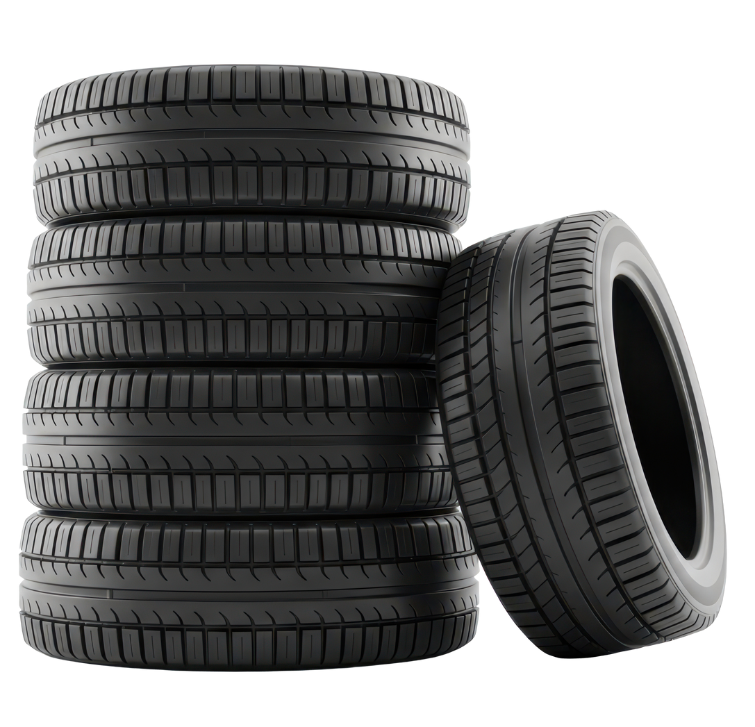 Une pile de cinq pneus de voiture noirs, l'un d'eux étant appuyé contre la pile.