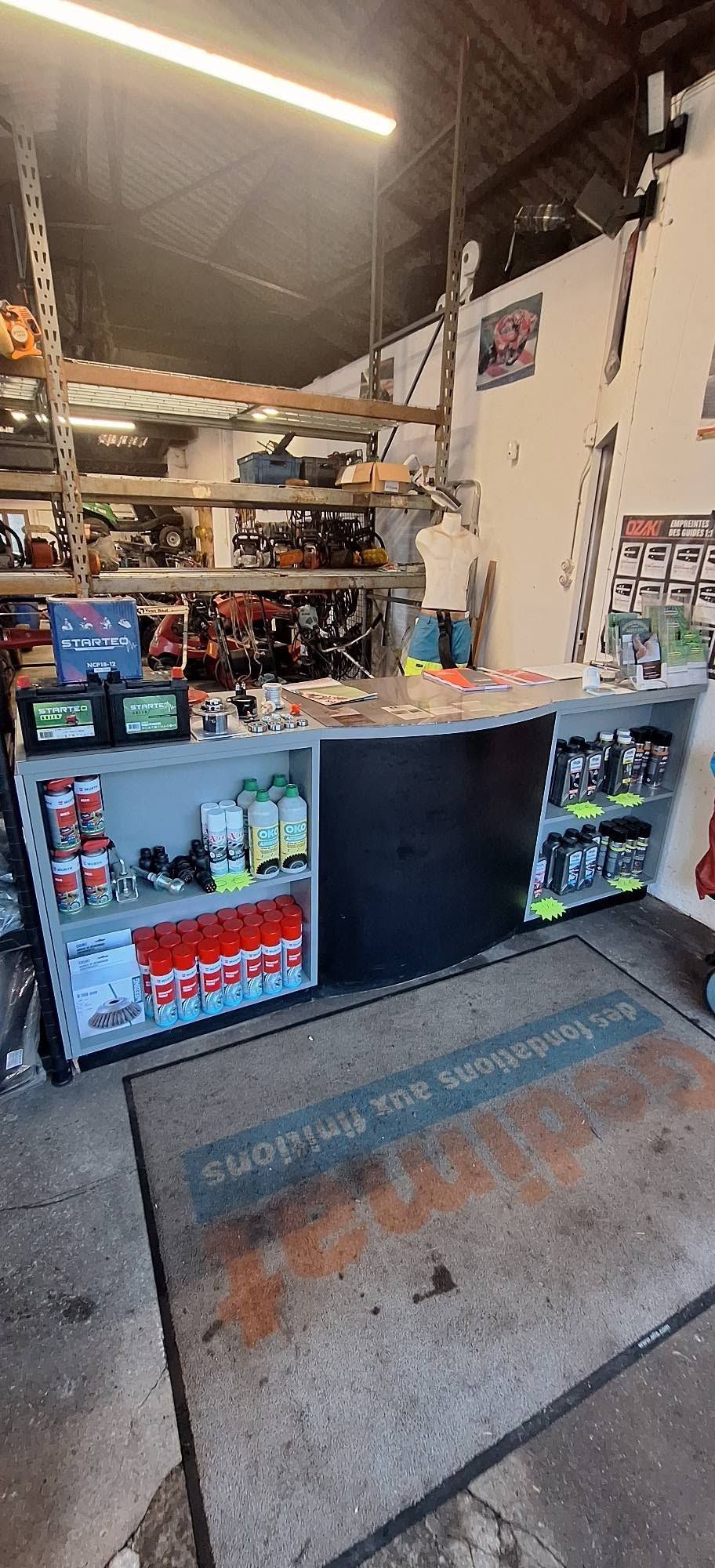 Petit comptoir de style garage avec des boissons et des en-cas sur des étagères, vu de l'entrée.