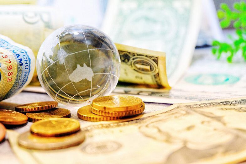 Globo terráqueo con dinero y monedas, que simboliza las finanzas globales.