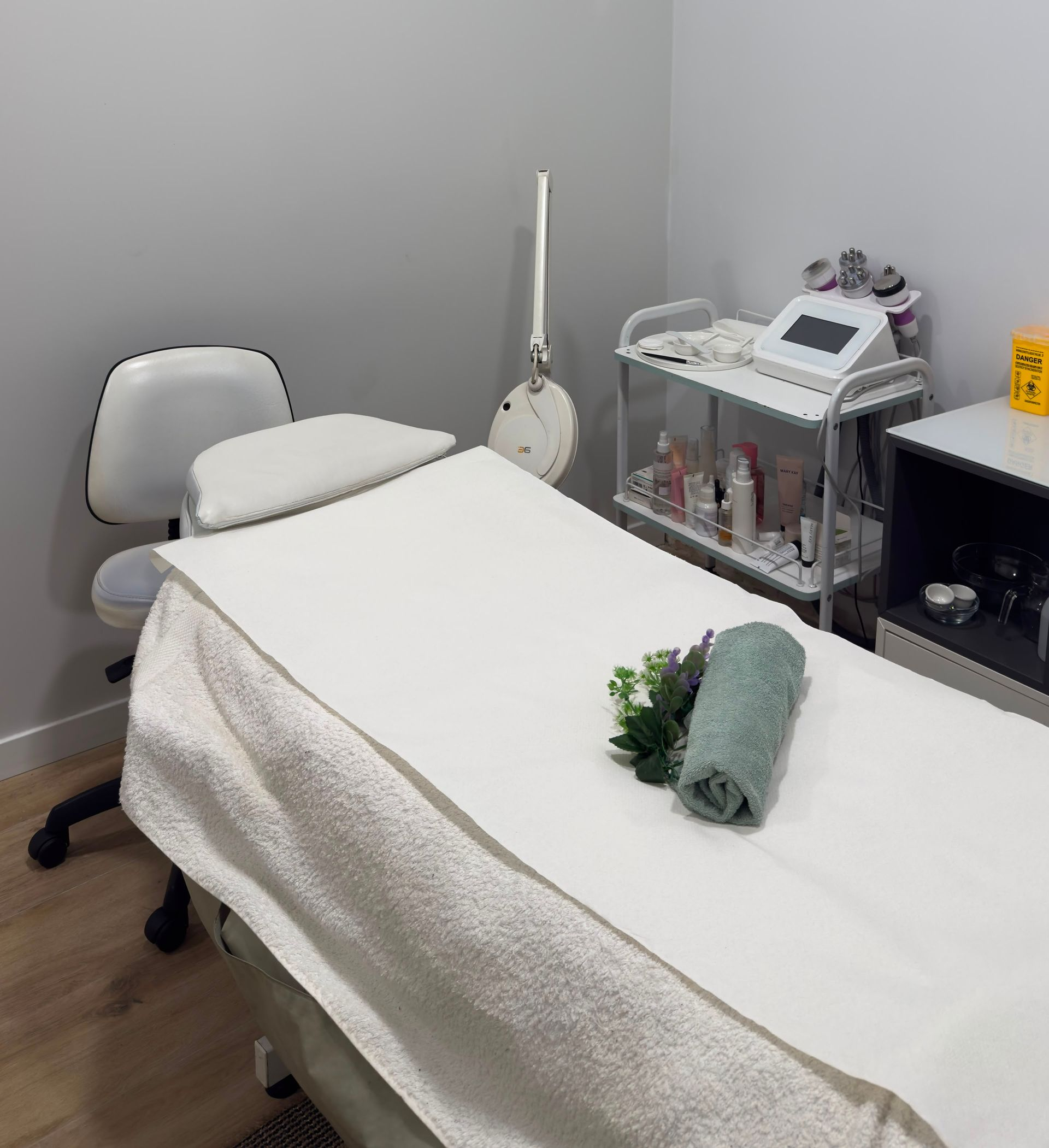 Terapeuta de spa dando un masaje facial a una clienta relajada en una camilla de masaje.