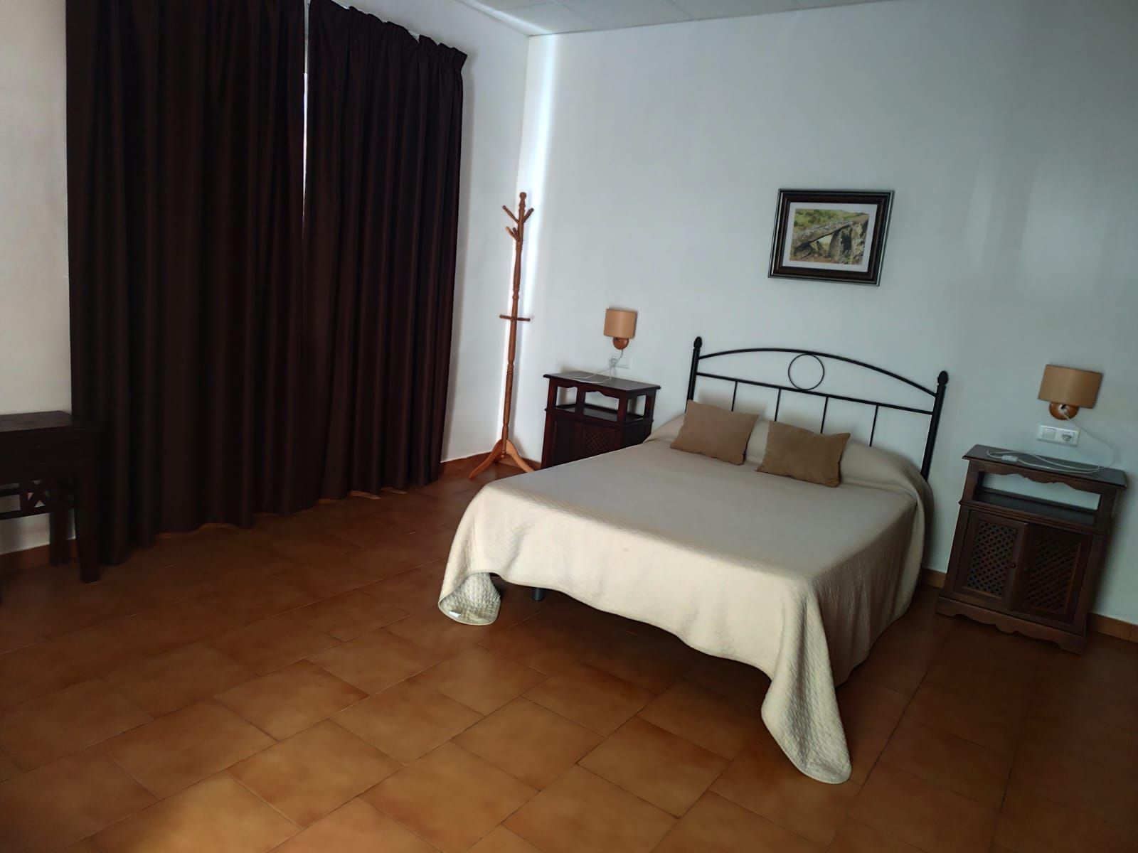 Un dormitorio con una cama y dos mesitas de noche.