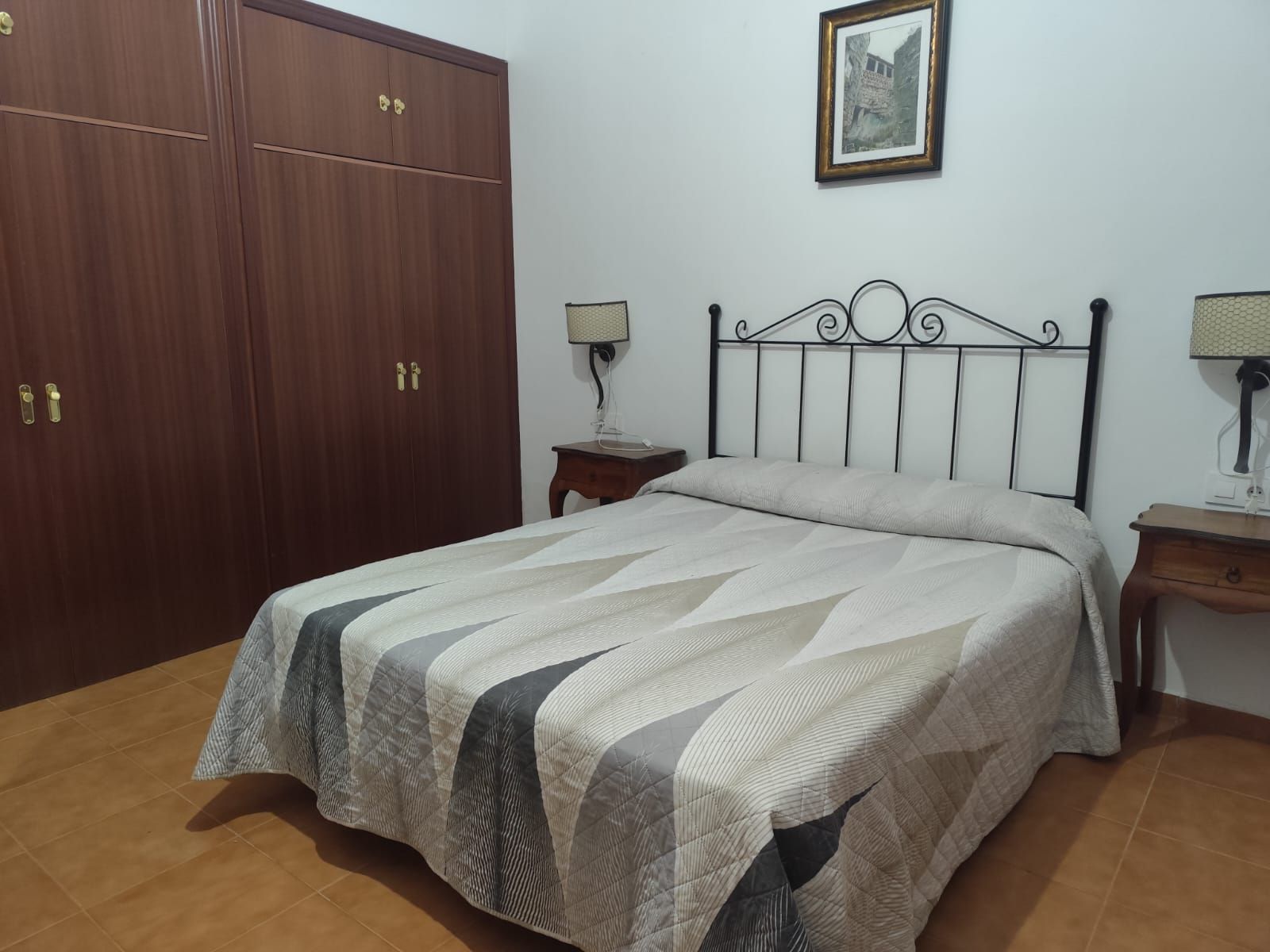 Un dormitorio con una cama grande y un cuadro en la pared.
