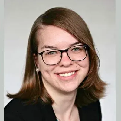 Einfache graue Umrisszeichnung einer Person mit rundem Kopf und rechteckigem Oberkörper auf grauem Hintergrund