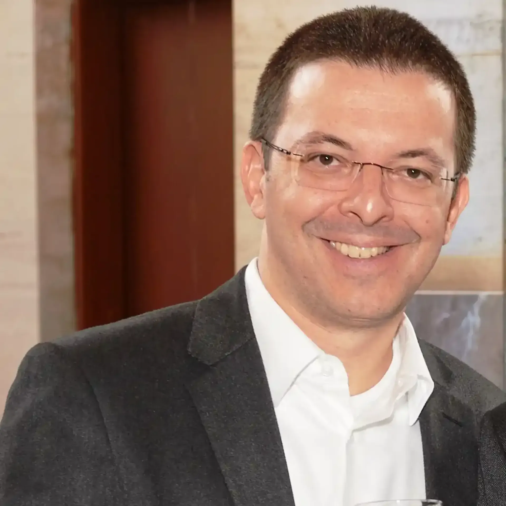 Hombre con los brazos cruzados. Lleva en los antebrazos un texto que dice 