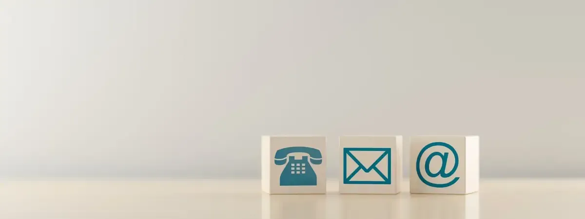 Iconos de contacto: teléfono, sobre y símbolo de correo electrónico en bloques blancos.