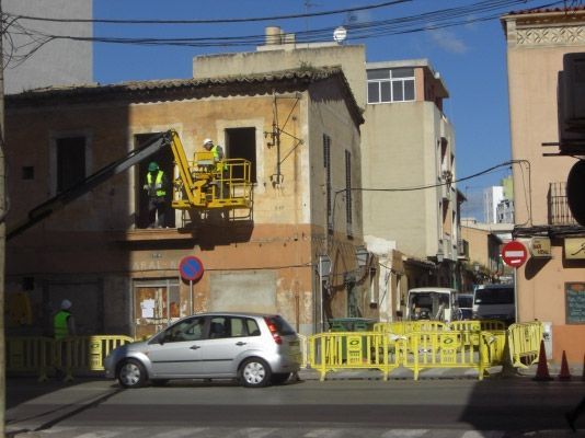 Un coche plateado está aparcado delante de una barrera amarilla.