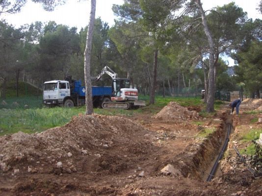 Un camión volquete está estacionado en medio de un campo de tierra.