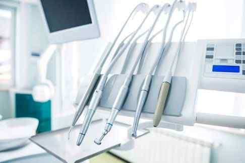 Una silla dental con instrumentos dentales en ella en un consultorio dental.