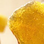 Un gros plan d'un morceau de gelée jaune sur une surface blanche.