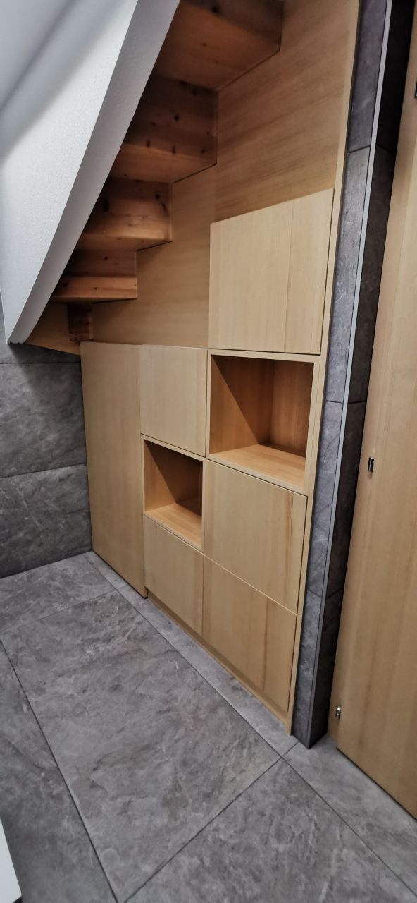 Un escalier en bois est encastré dans le mur d'une pièce.