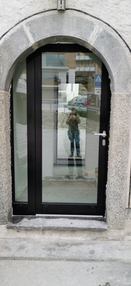 Une personne se prend en photo dans un miroir devant une porte.