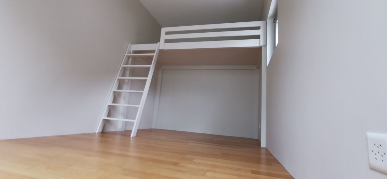 Une pièce vide avec un lit superposé et une échelle.