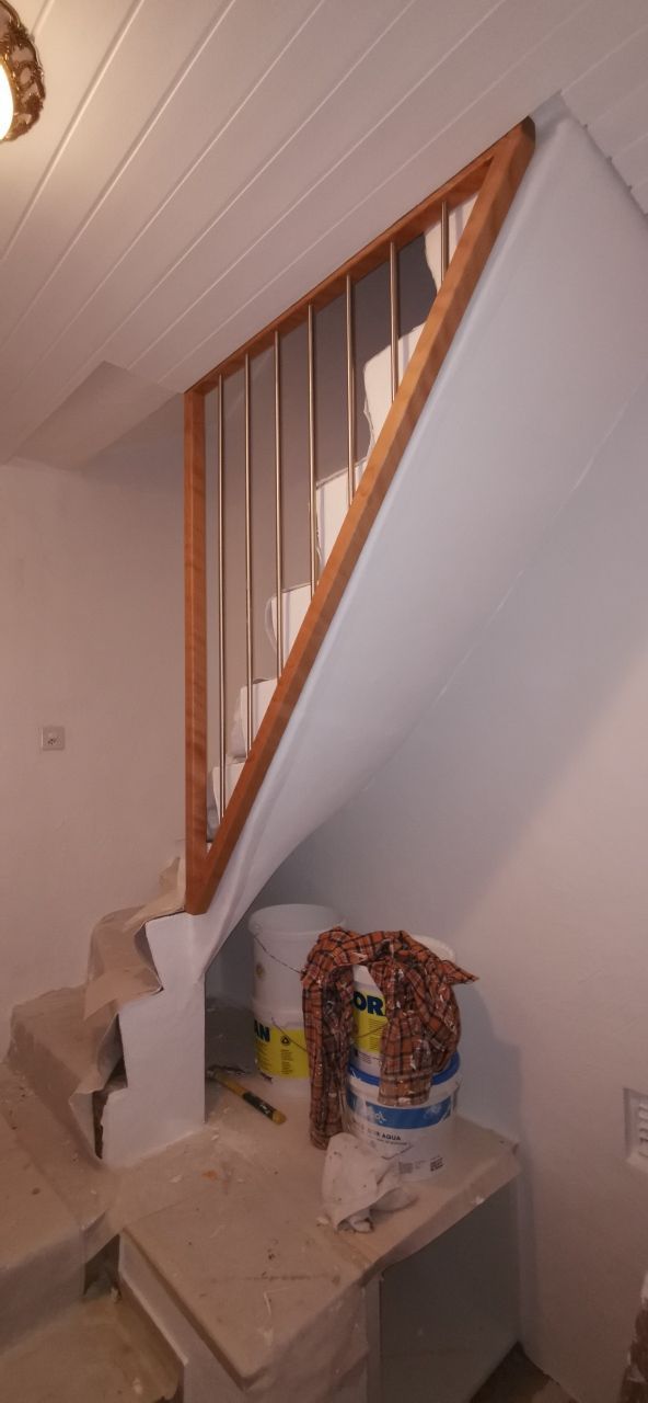Un escalier avec une rampe en bois est en cours de construction dans une pièce.