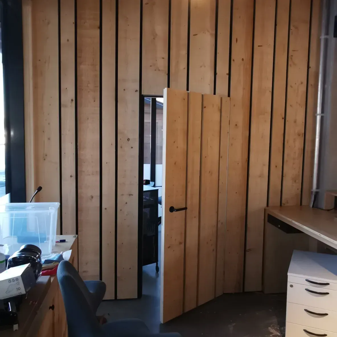 Une pièce avec des boiseries et une porte ouverte