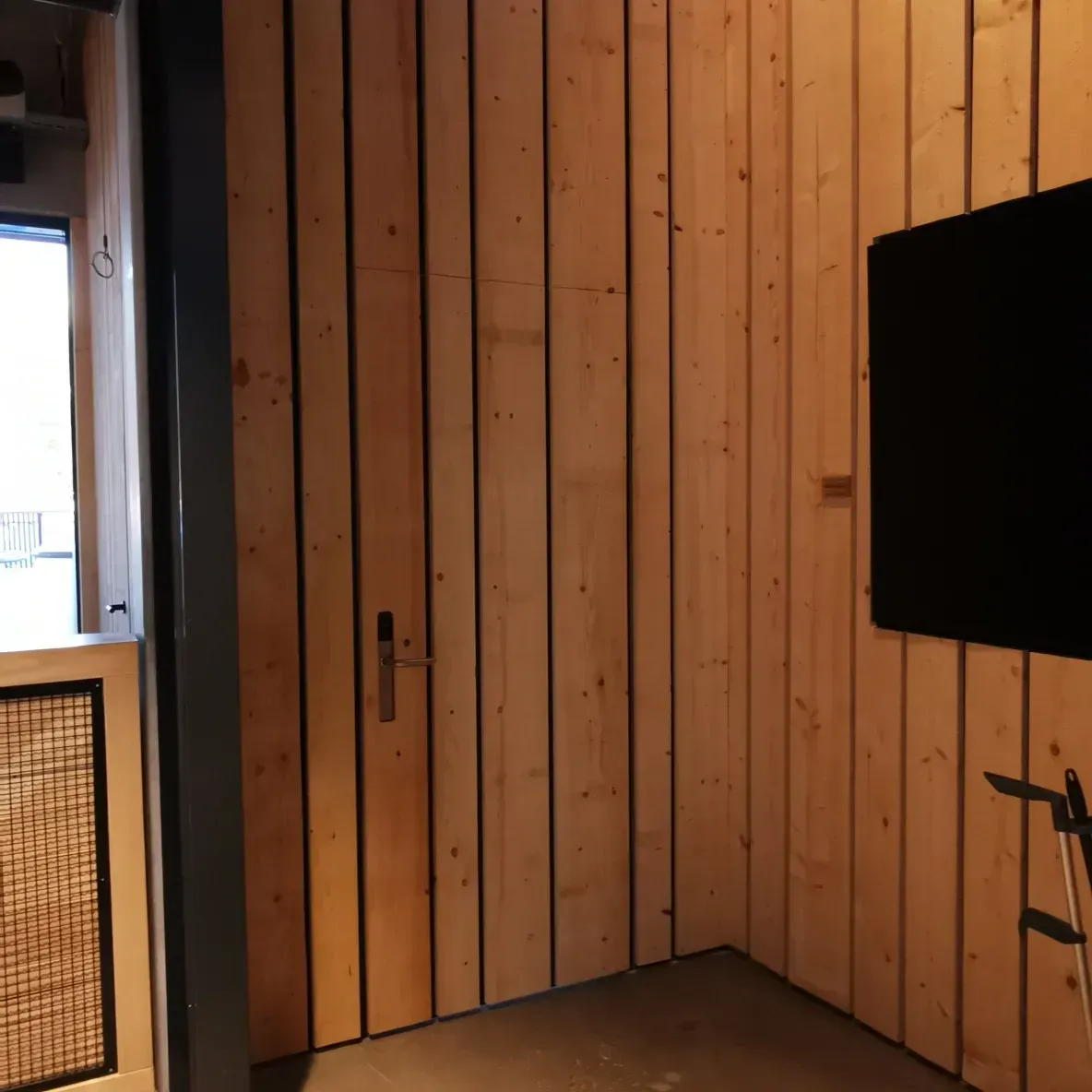 Une pièce avec des boiseries et une télévision fixée au mur