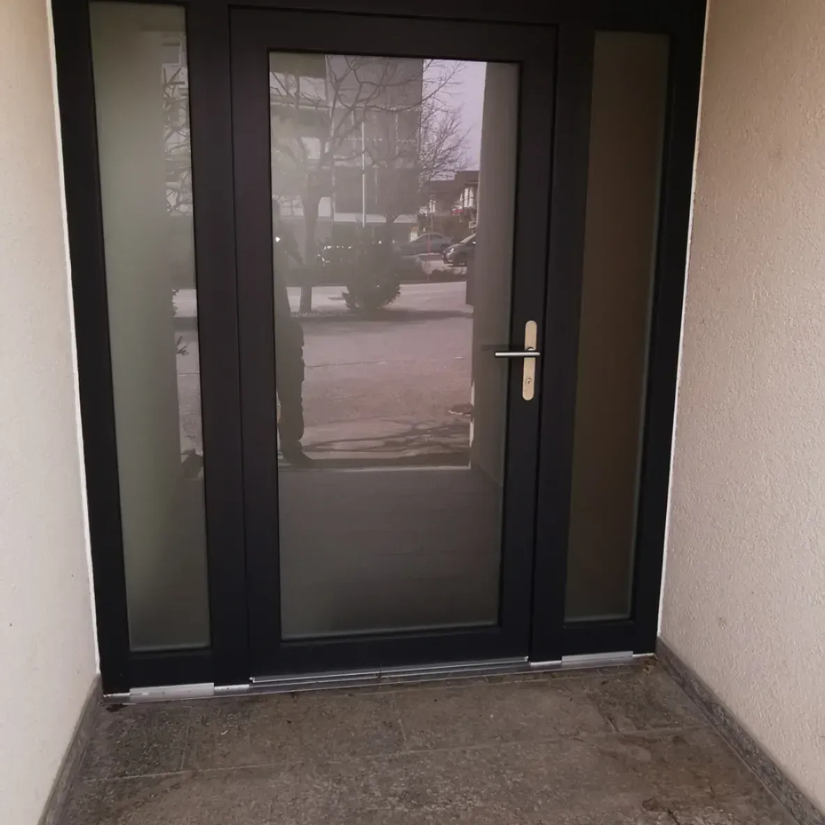 Une porte noire avec le reflet d'une voiture à l'intérieur