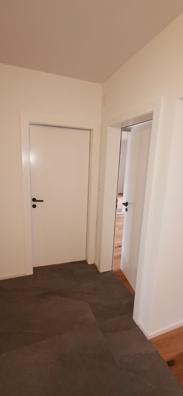 Une pièce vide avec une porte et des escaliers en arrière-plan.