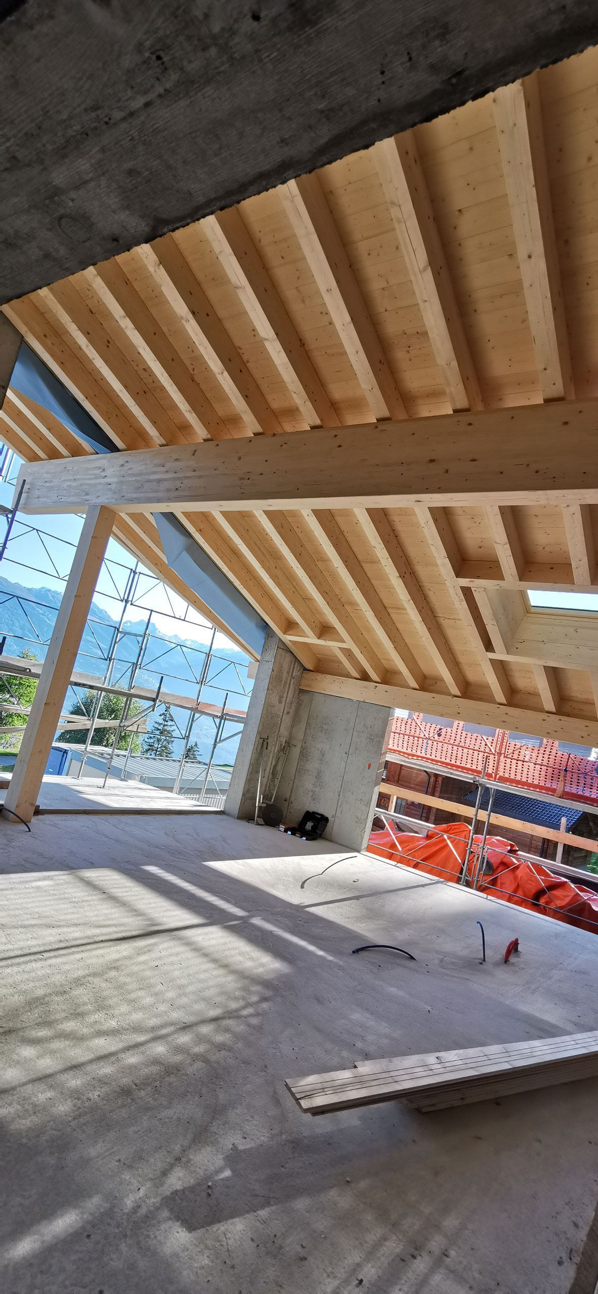 Une pièce avec un plafond en bois et une grande fenêtre.