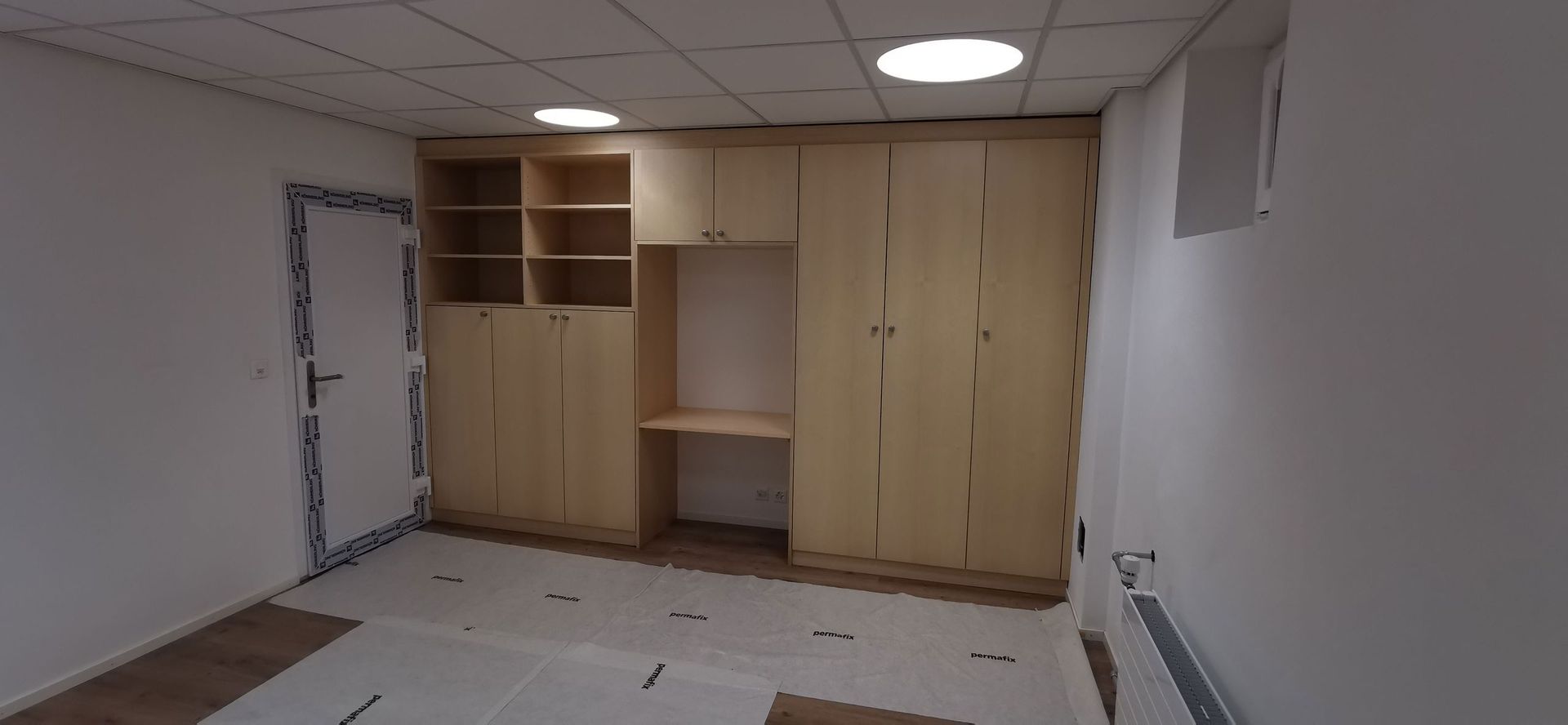 Une pièce avec beaucoup d'armoires et d'étagères en bois