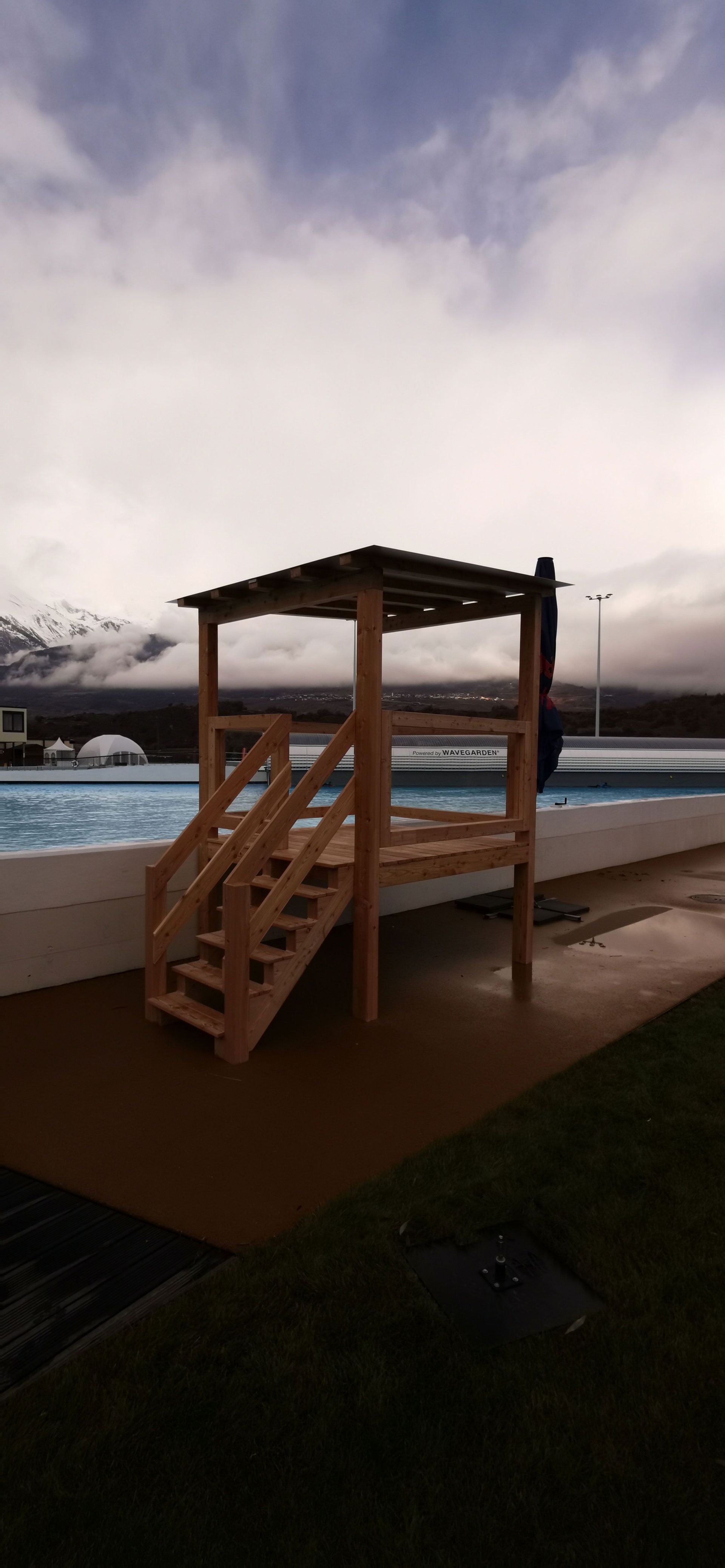 Une structure en bois avec des escaliers menant à une piscine