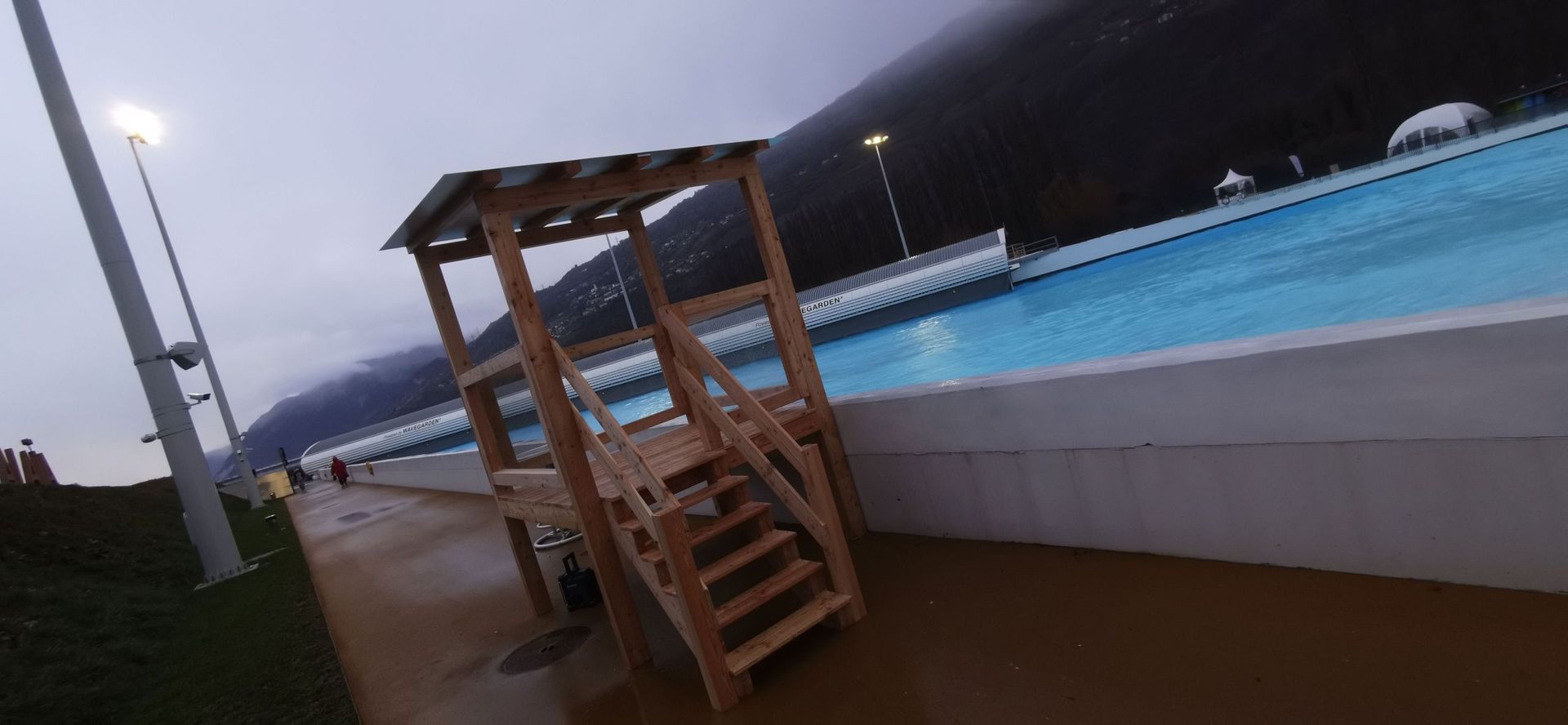 Une tour de sauveteur se trouve à côté d'une piscine.