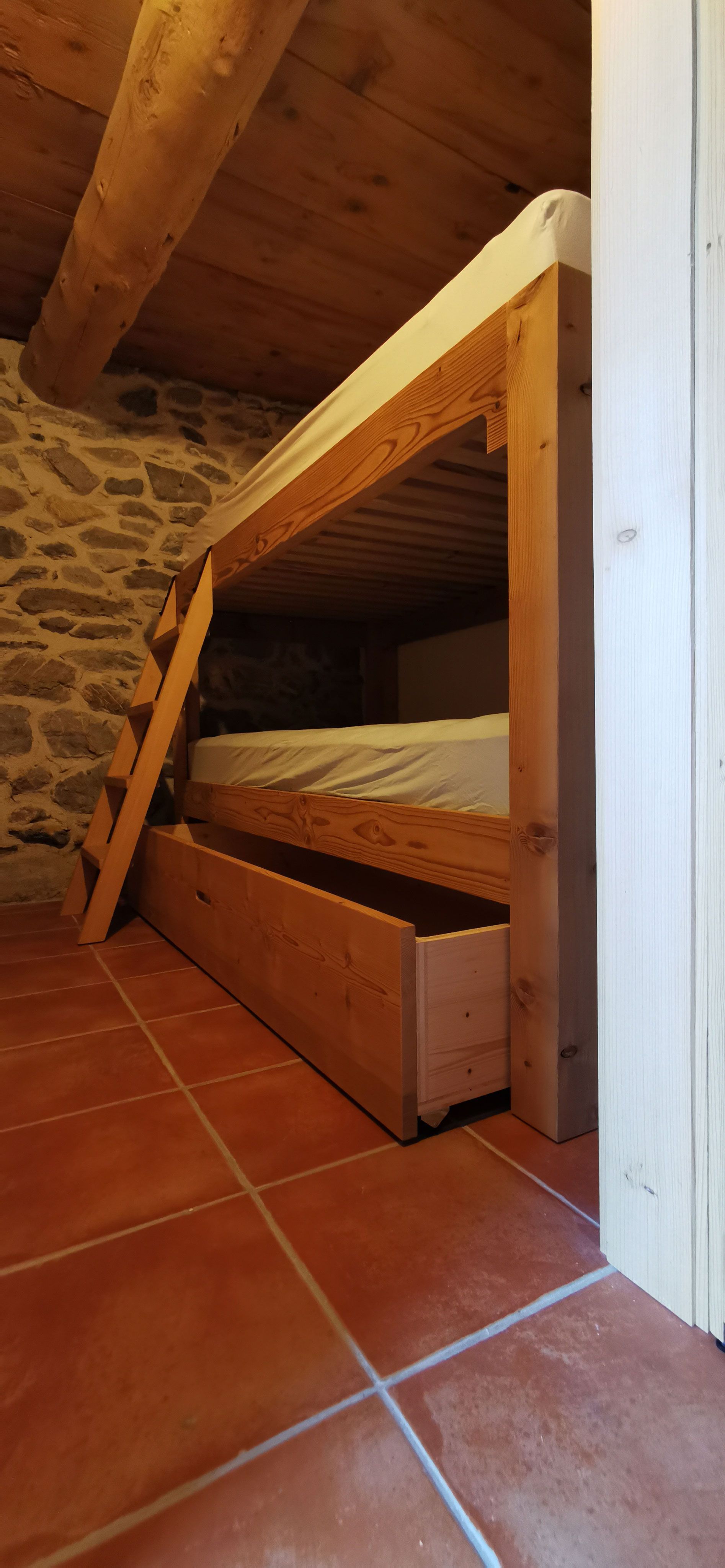 Un lit superposé avec un tiroir en dessous dans une chambre.