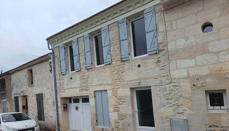Une maison attenante avec des fenêtres et des volets ainsi qu'une porte d'entrée vitrée