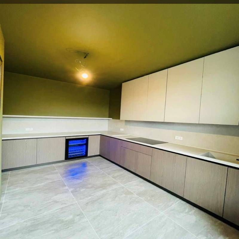 Una cucina con soffitto verde e mobili bianchi