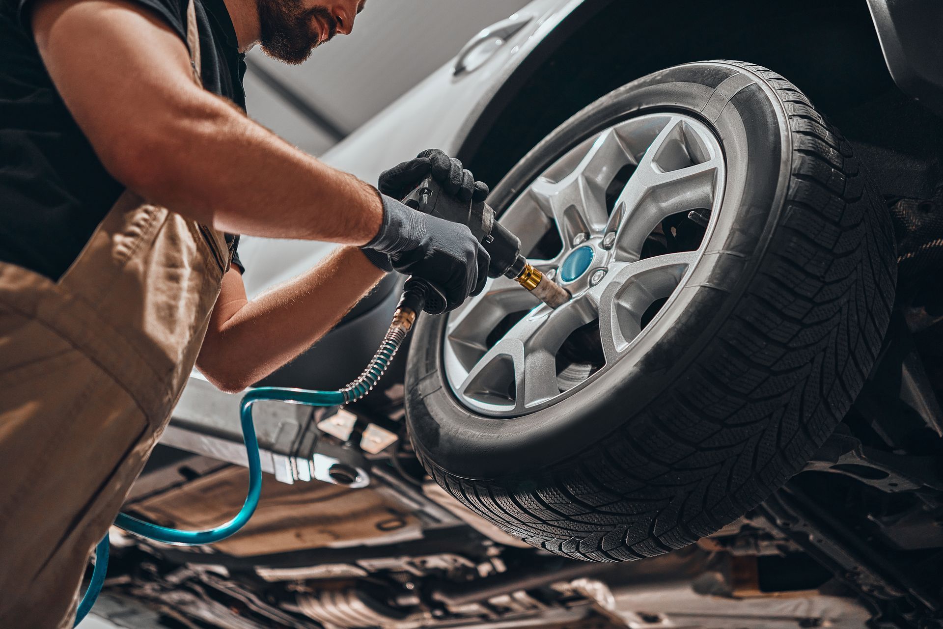 Un mécanicien qui fixe une roue sur une voiture.