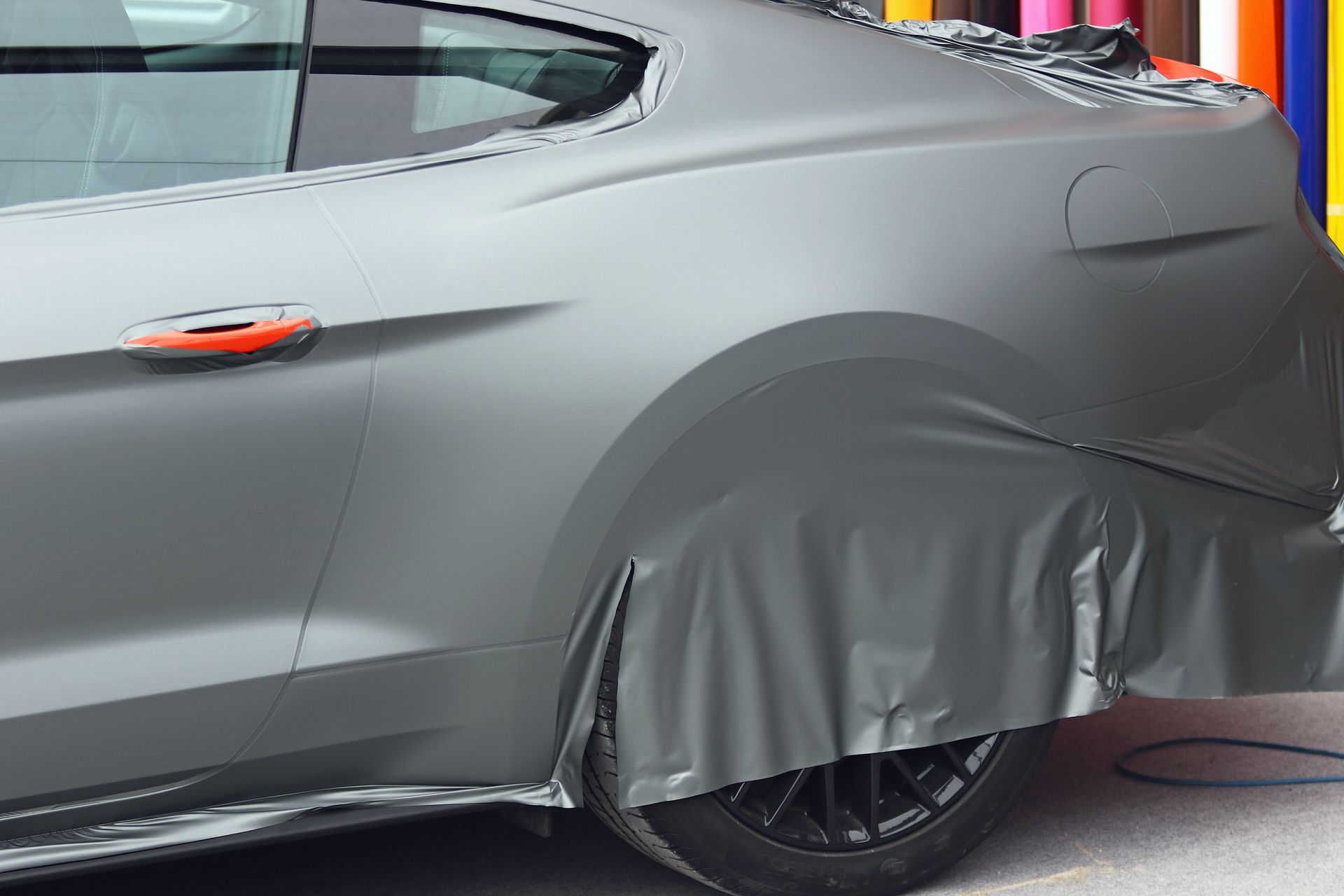 Un covering gris posé sur une voiture.