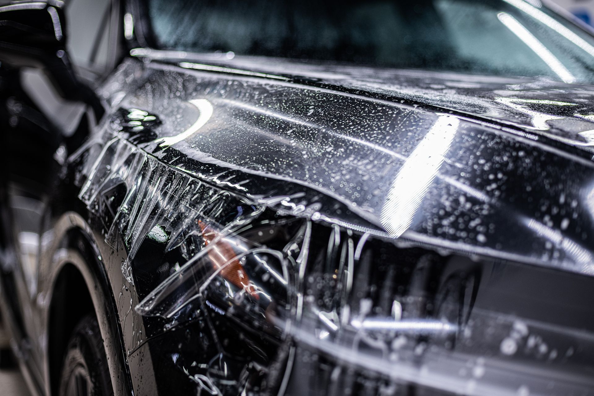 Gros plan sur la pose d'un PPF sur une voiture.