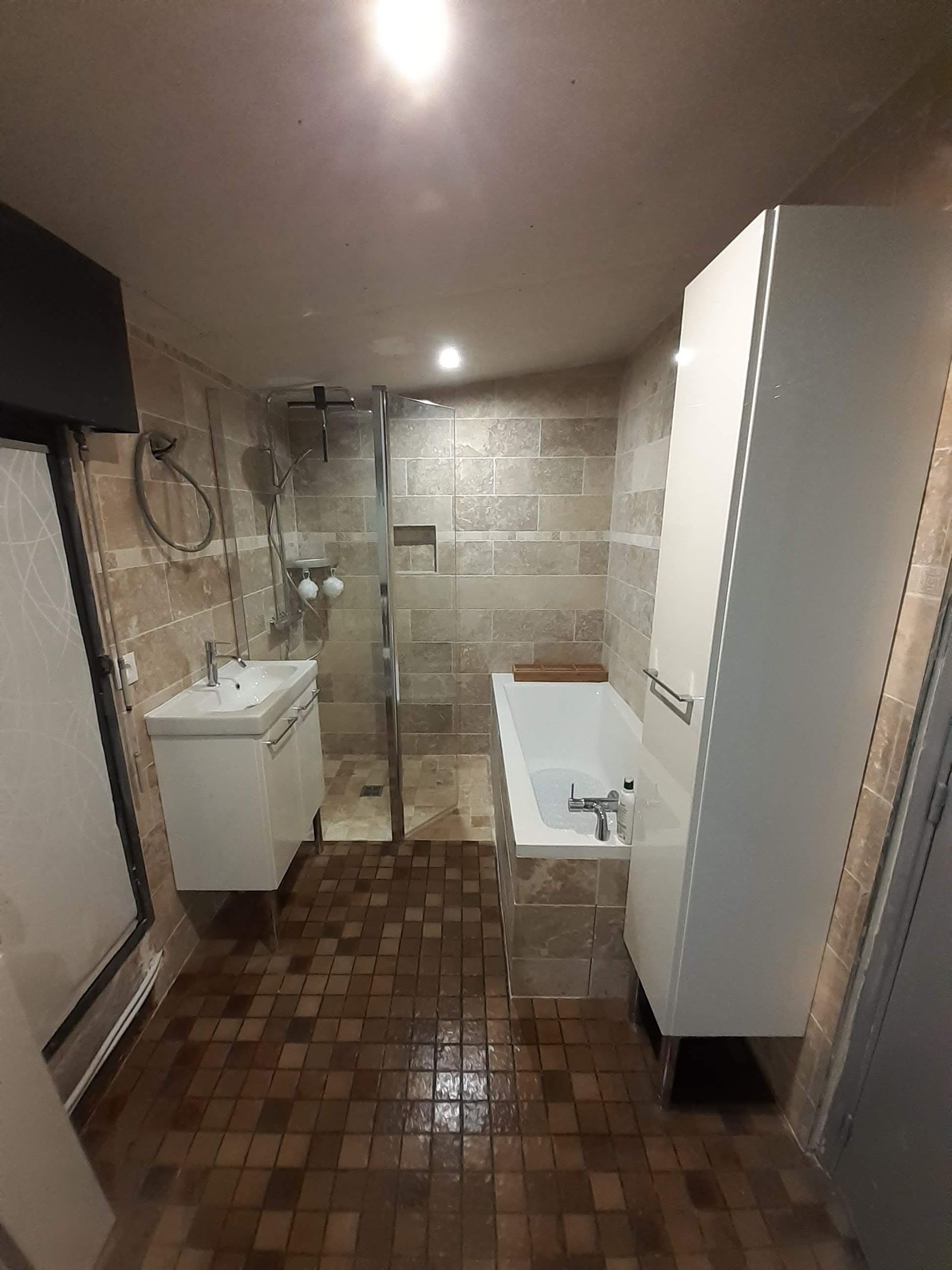 Un couloir dans une maison avec un lit et un miroir sur le mur.