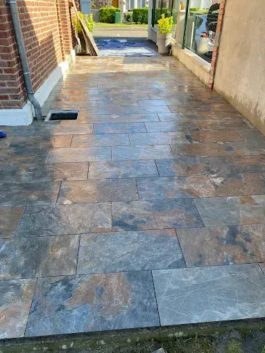 Une allée carrelée menant à un bâtiment en briques.