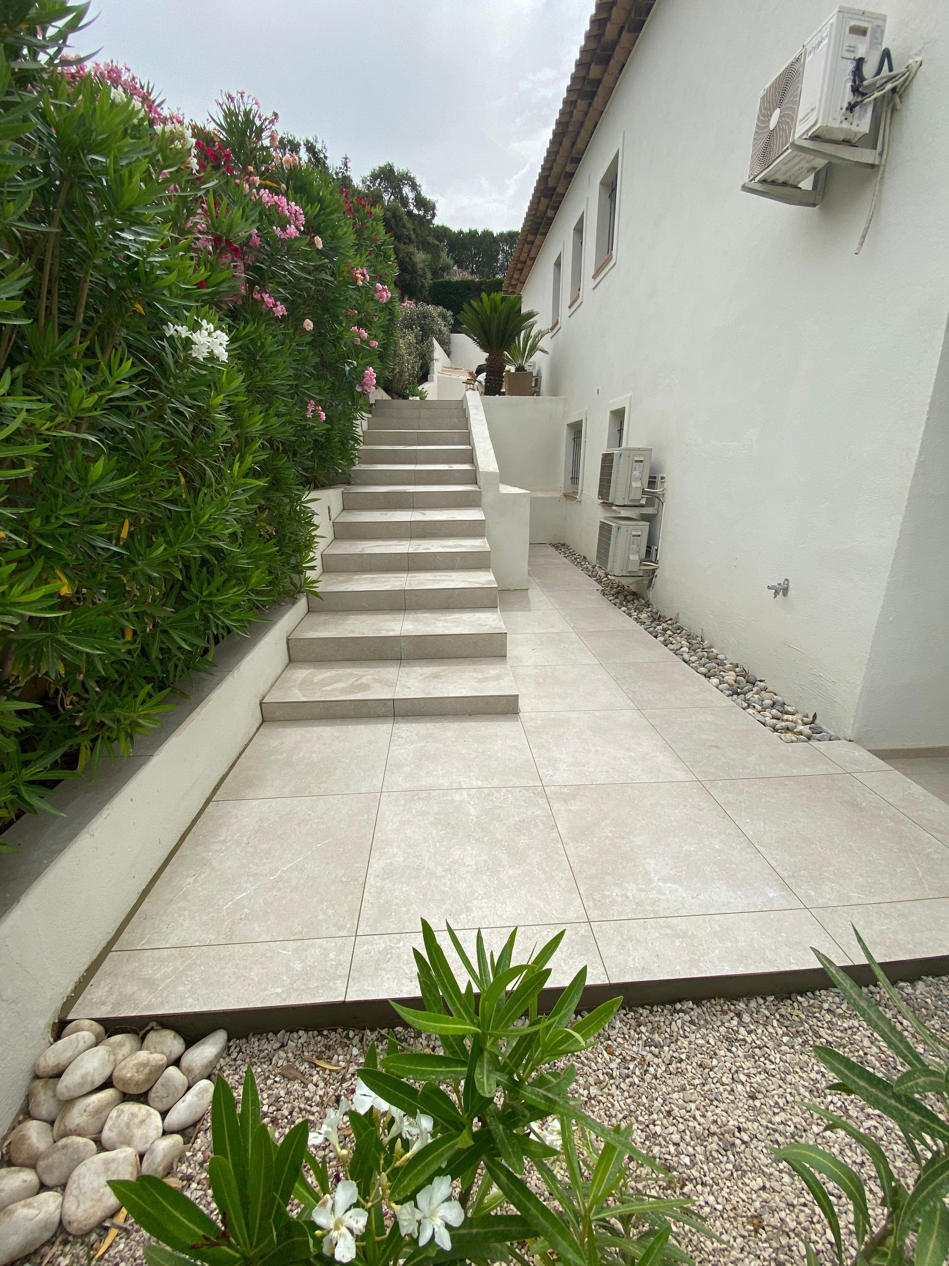 Un seau de sable et une truelle sont posés sur une surface en béton.